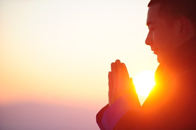 Image of Man Meditating with Sun In Background